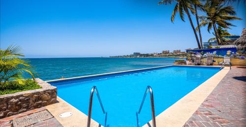 a swimming pool with the ocean in the background at Oceanfront-Ocean View in Bucerias Casita Oasis Condo - Large Studio in Bucerías
