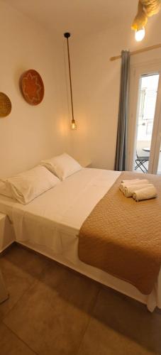 a bedroom with a large white bed with a window at Joannes Vacation Rooms in Adamas