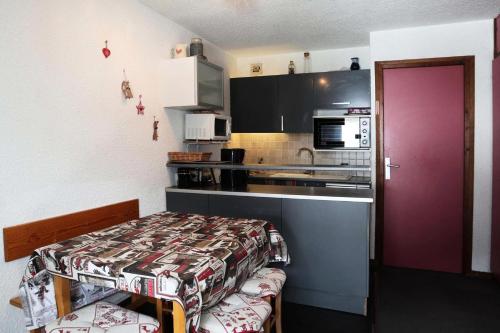 Cette petite chambre dispose d'une cuisine avec une porte violette. dans l'établissement Résidence Le Cairn - Résidence Cairn - Studio 4 personnes vue pistes MAE-6291, aux Orres