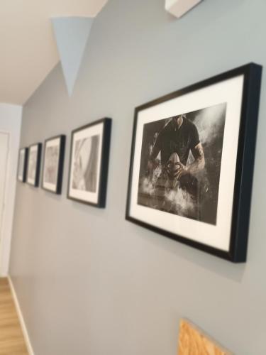 a row of framed pictures on a wall at T2 l'ovalie, 4pers , 4lits, wifi in Agen