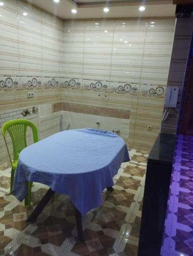 a room with a blue table and a green chair at waltit apartement in Agadir