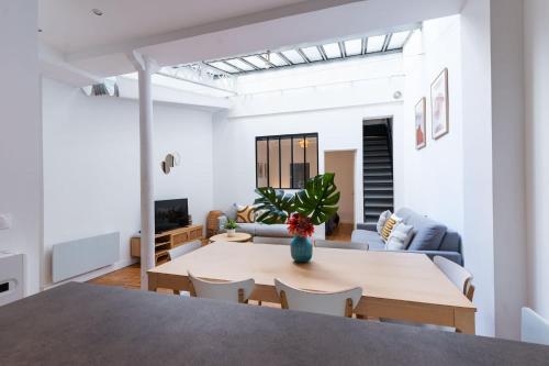un salon avec une table et un canapé dans l'établissement Loft house 2 BR Bastille AC by LCC Agency, à Paris