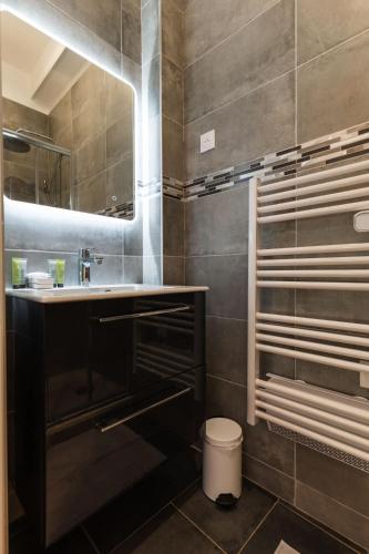 une salle de bain avec un lavabo et un miroir dans l'établissement Loft house 2 BR Bastille AC by LCC Agency, à Paris