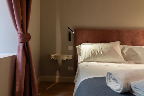 a bedroom with a bed and a sink next to a window at Palazzo Biasini by Postcardsfrom in Verona