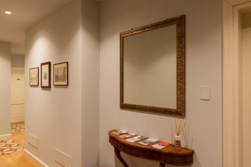 a mirror on a wall with a wooden table at Palazzo Biasini by Postcardsfrom in Verona