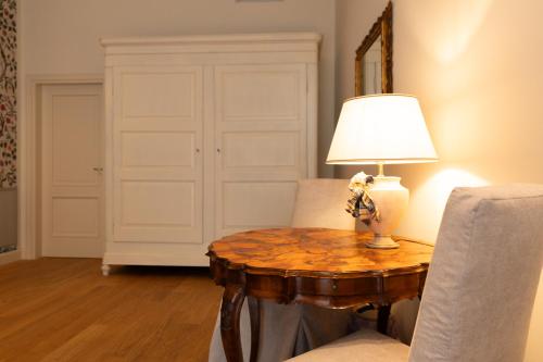 a room with a table with a lamp and chairs at Palazzo Biasini by Postcardsfrom in Verona