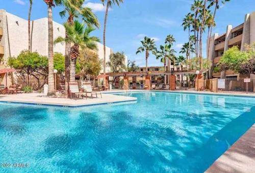 a large swimming pool with palm trees in a resort at Old Town Condo with 2 King Size Suites in Scottsdale