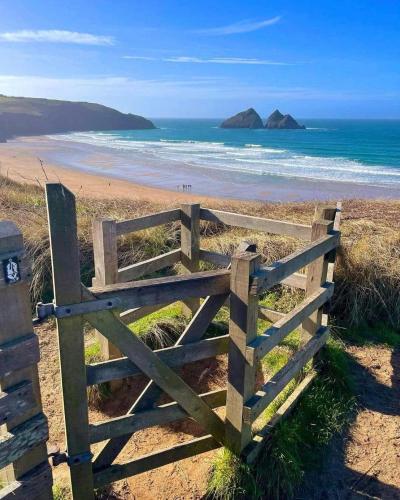 a wooden gate on a beach with the ocean at Newquay Bay Holiday Resort Caravan 142 in Newquay Bay Resort