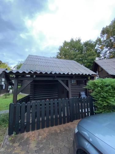 チャテジ・オプ・サヴィにあるHiška Nisaのフェンスの後ろにある黒い屋根の木造小屋