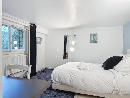 une chambre blanche avec un lit et une chaise dans l'établissement Villa Rosière, à Villers-sur-Mer