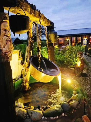 a water fountain in a garden with a gold bucket at The Hideaway Muff in Muff
