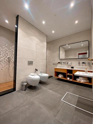 a bathroom with a toilet and a sink and a mirror at Crown Boutique Hotel in Durrës