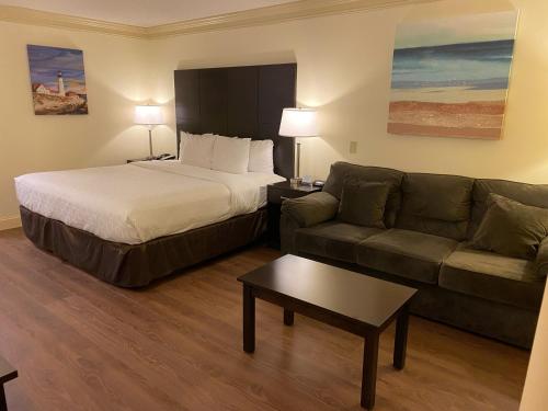 a hotel room with a bed and a couch at Clarion Hotel & Conference Center in Toms River