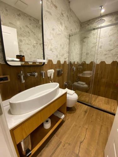 a bathroom with a sink and a toilet and a shower at Crown Boutique Hotel in Durrës
