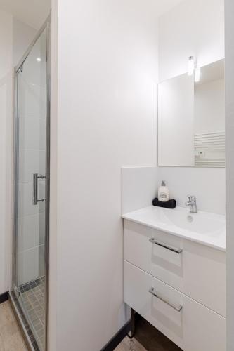 une salle de bain blanche avec un lavabo et une douche dans l'établissement M2 SWEET HOMES Angoulême I Secteur Gare SNCF I Maison 1 Chambre extérieur privé au calme - Animaux acceptés, à Angoulême