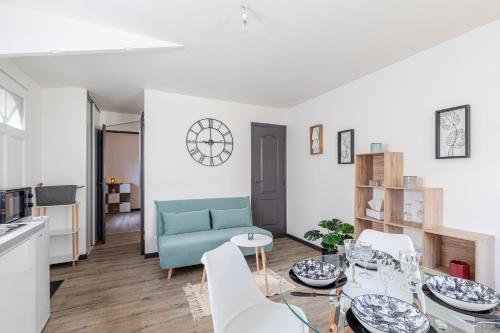 un salon avec un canapé bleu et une table dans l'établissement M2 SWEET HOMES Angoulême I Secteur Gare SNCF I Maison 1 Chambre extérieur privé au calme - Animaux acceptés, à Angoulême