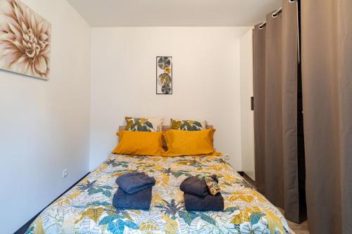 une chambre avec un lit avec des oreillers jaunes dans l'établissement M2 SWEET HOMES Angoulême I Secteur Gare SNCF I Maison 1 Chambre extérieur privé au calme - Animaux acceptés, à Angoulême