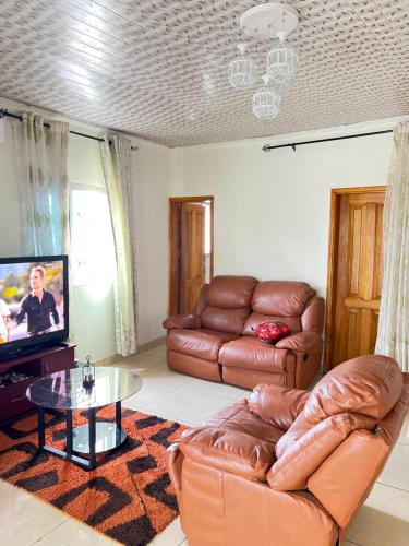 a living room with a couch and a tv at QATARI palace in Douala