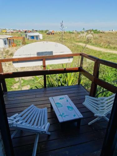 two chairs and a table on a deck at Carmela Suites Cabo Polonio in Cabo Polonio
