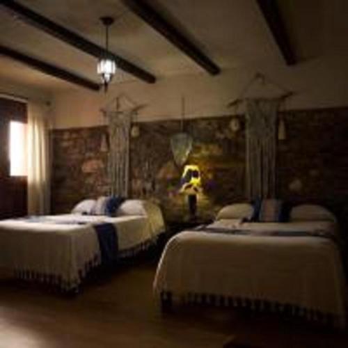 a bedroom with two beds in a room at Grann Posada Xilitla in Xilitla