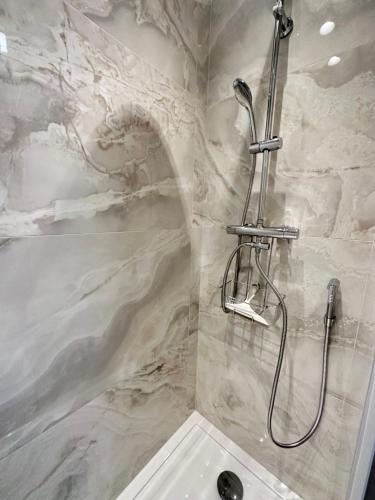 a bathroom with a shower with a stone wall at Appartamento Aria del Mare in Ventimiglia