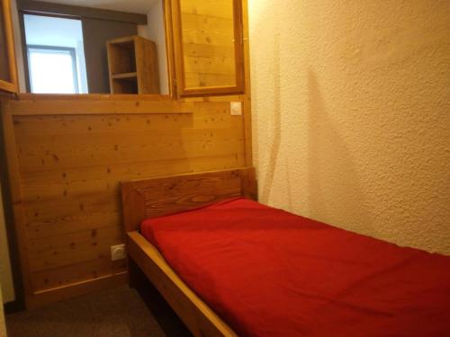 une petite chambre avec un lit avec une couverture rouge dans l'établissement Residence 3000 - Studio pour 4 Personnes 24, à Mâcot La Plagne