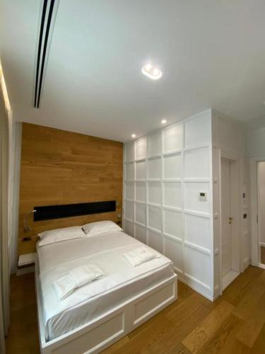 a bedroom with a large bed with white walls at Crown Boutique Hotel in Durrës