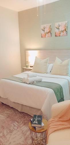 a bedroom with a large white bed with a book on it at Sea Breeze Manor - Aqua Unit in East London