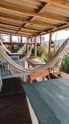 a hammock on a patio with a table and chairs at Carmela Suites Cabo Polonio in Cabo Polonio