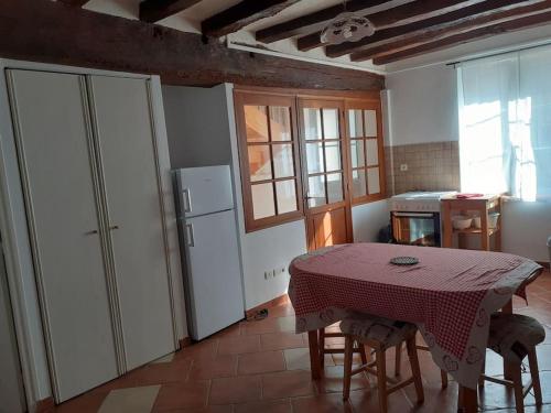 une cuisine avec une table et des chaises dans une pièce dans l'établissement Maison pour 6 personnes, à Villebernier