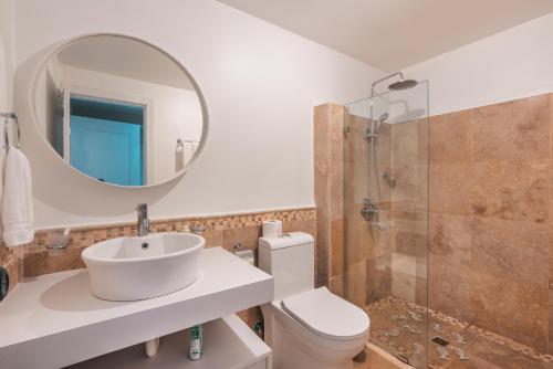 a bathroom with a sink and a mirror and a toilet at Magnificent villa with ocean view in Puerto Bahia in Santa Bárbara de Samaná