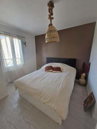 une chambre avec un lit blanc avec deux oreillers dessus dans l'établissement Spacieux et Lumineux proche CDG-PARIS-PARCS, à Marly-la-Ville