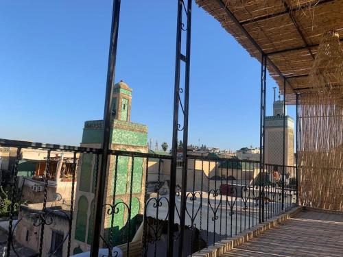 a gate to a building with a clock tower behind it at Dar ZaZ in Fès