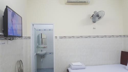 a bathroom with a toilet and a tv on a wall at Tai Nguyen Motel in Vung Tau
