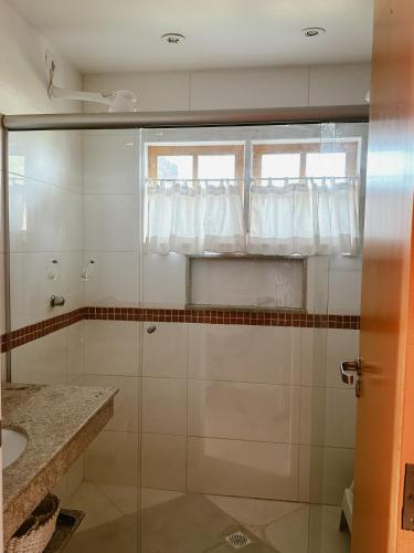 a bathroom with a shower and a sink and a window at Casa Ponta de Areia in Corumbau
