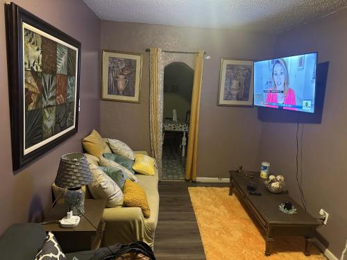 a living room with a couch and a flat screen tv at Tower of Little Italy in Niagara Falls