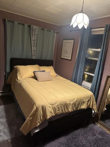 a bedroom with a bed with a yellow blanket at Tower of Little Italy in Niagara Falls
