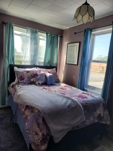 a bedroom with a large bed with blue curtains at Tower of Little Italy in Niagara Falls