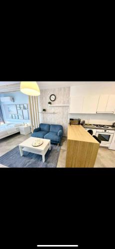 a living room with a blue couch and a table at Caesars Studio Flat in İskele