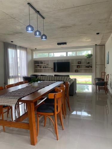 a dining room and living room with a table and chairs at Costa Esmeralda Casa Ecu in Costa Esmeralda