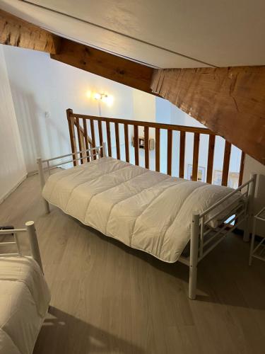 un grand lit dans une chambre avec un plafond en bois dans l'établissement Appartement le grau du roi, au Grau-du-Roi