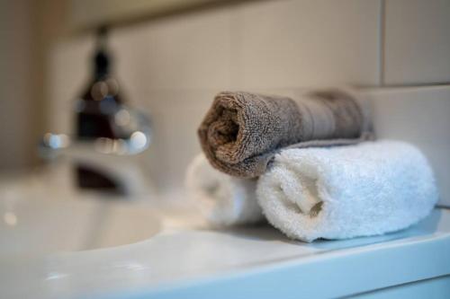 a pile of towels sitting on top of a sink at Te Anau Cottage in Te Anau