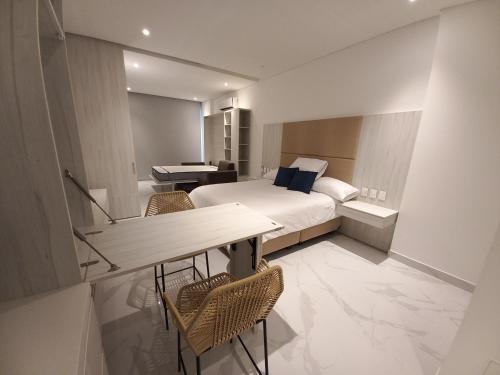 a hotel room with a bed and a desk and a piano at Playa y Relax comodidad junto al mar! in Santa Marta