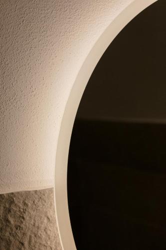 a white wall with a round mirror on it at Le Fantine Rooms in Campomarino