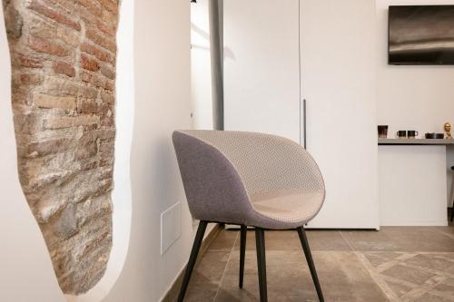 a chair in a room with a brick wall at Le Fantine Rooms in Campomarino