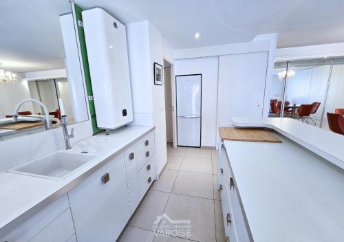 une cuisine blanche avec un évier et un plan de travail dans l'établissement Les Gregoriennes T2 Climatisé Hyeres Centre-Terrasse-Parking-Wifi, à Hyères