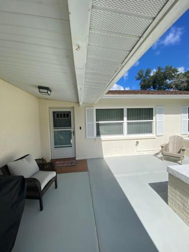 an open patio with a couch and a chair at Easy BNB Close to Beaches, Billiard,Ping-Pong Table, Lanai, Fire Pit, BBQ, Patio, Back Yard in New Port Richey