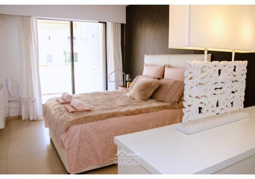 - une chambre avec un lit et 2 serviettes roses dans l'établissement Les Gregoriennes T2 Climatisé Hyeres Centre-Terrasse-Parking-Wifi, à Hyères
