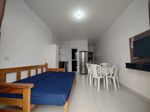 a bedroom with a bed and chairs and a kitchen at Condominio Boa Vista in Pontal do Paraná