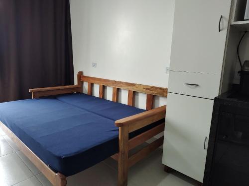 a bedroom with a bed and a white refrigerator at Condominio Boa Vista in Pontal do Paraná